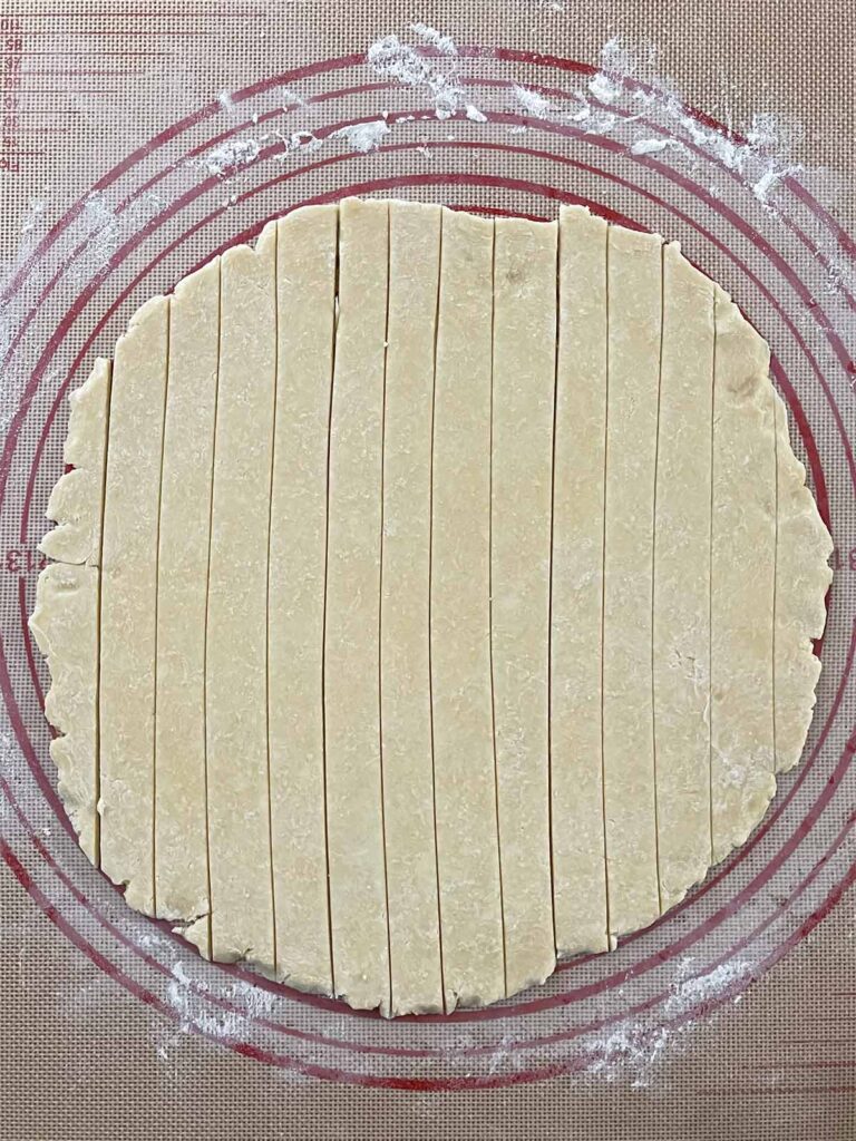 Pie dough cut into strips for the lattice crust of the cranberry apple pie recipe.