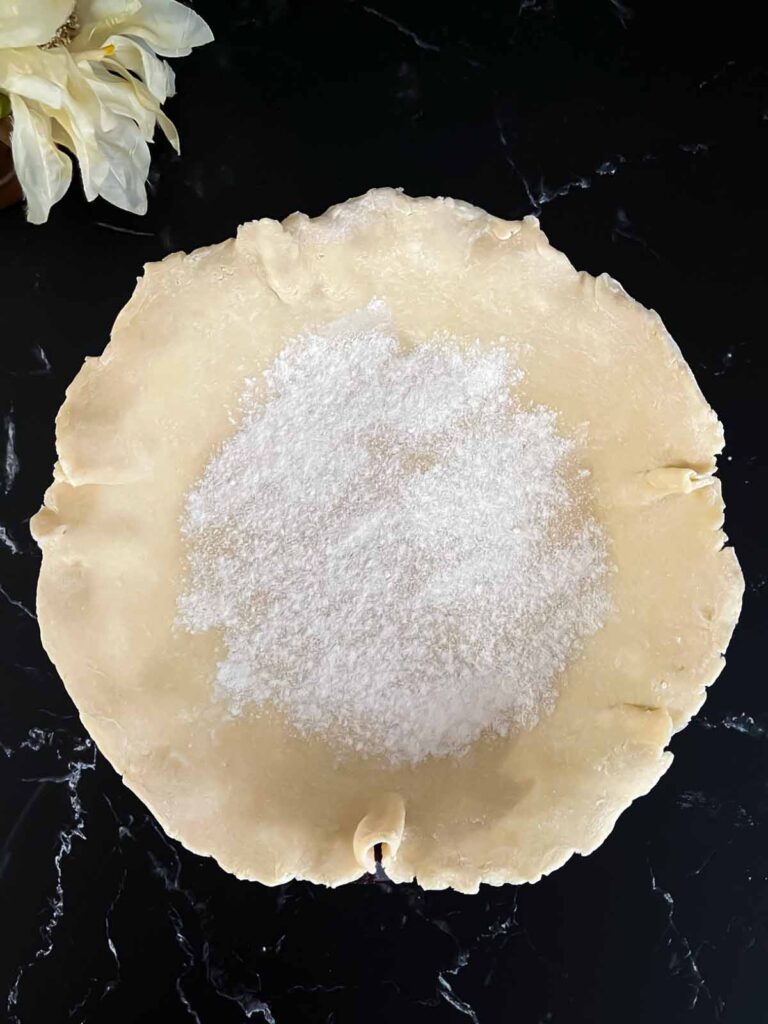 Crust dust sprinkled over the bottom of the pie dough for the cranberry apple pie recipe.