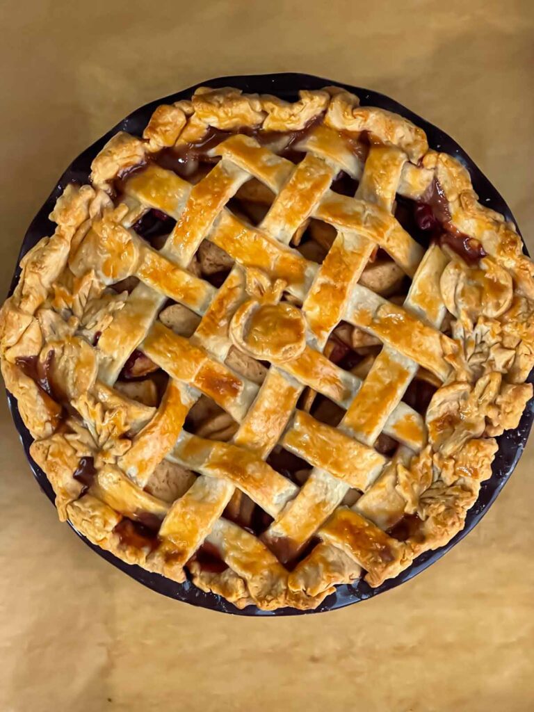 Baked cranberry apple pie on a parchment paper lined baking sheet.