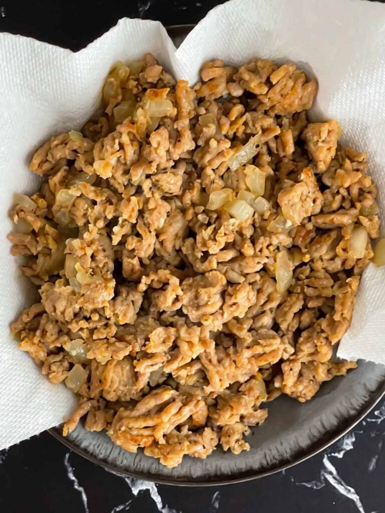 Italian sausage in a paper towel lined bowl.