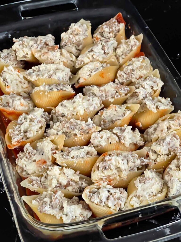 Unbaked Italian stuffed shells in a casserole dish.