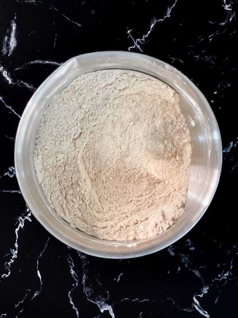 Dry ingredients whisked together in a metal bowl for the zucchini bread recipe.