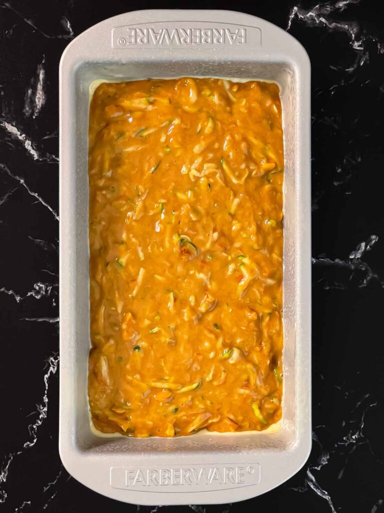 Zucchini bread batter in a greased loaf pan.