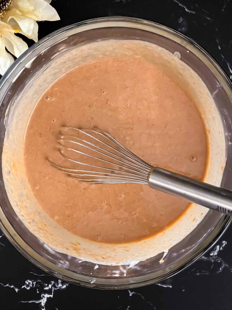 Apple butter pie mixture whisked together in a glass bowl.