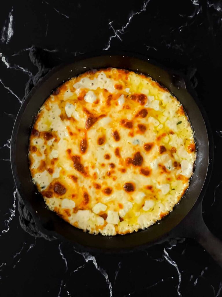 Baked Ricotta dip in a cast iron skillet.