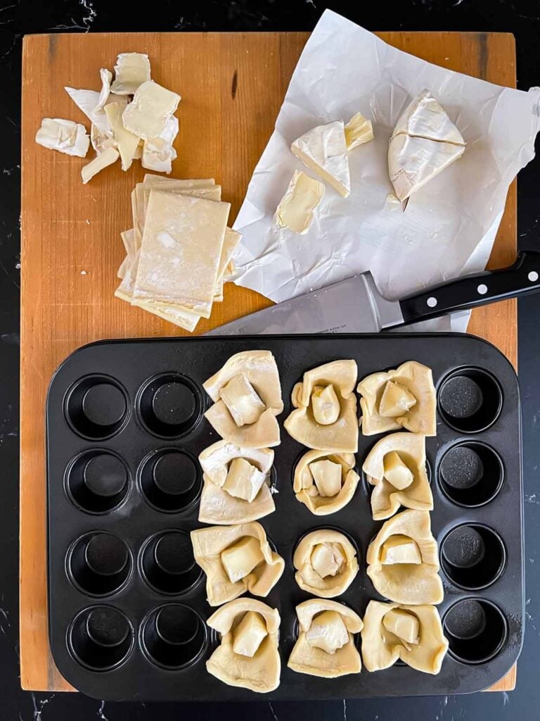 Puff pastry being filled with brie cheese.