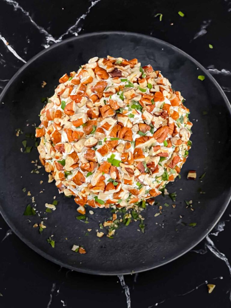 A garlic herb cheese ball just coated with pecans.