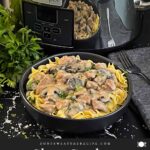 Slow Cooker Beef Stroganoff in a black bowl, garnished with chopped parsley.