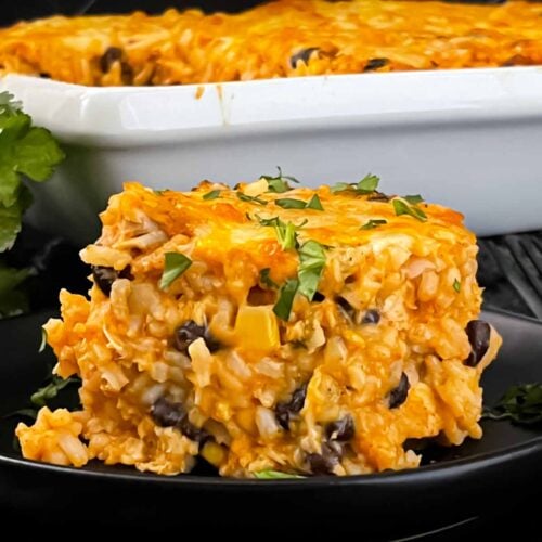 Chicken enchilada rice casserole on a black plate.