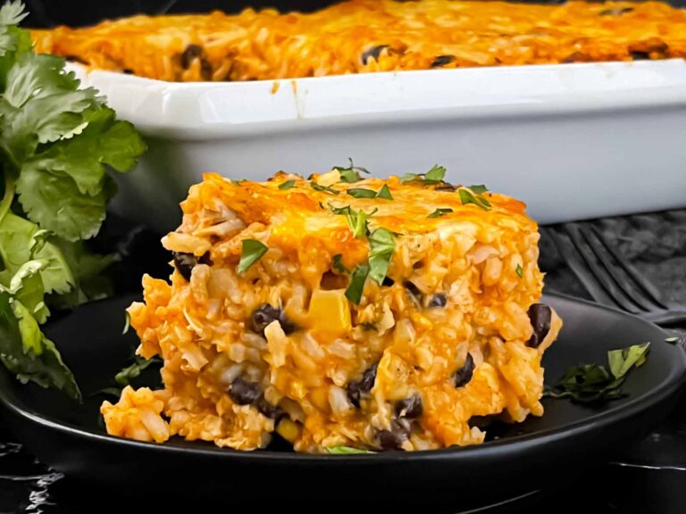 Chicken enchilada rice casserole on a black plate.