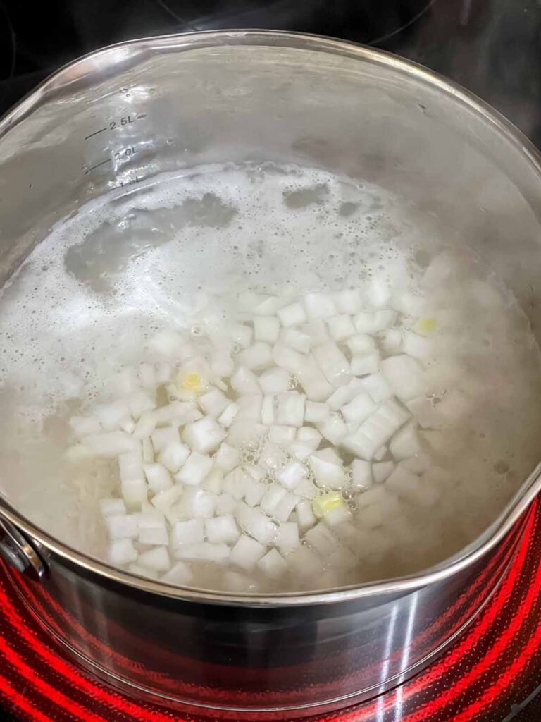 Rice with onions cooking in a saucepan.