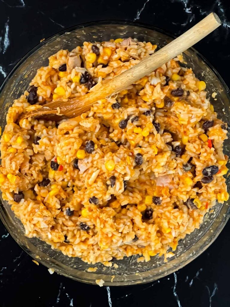 Chicken enchilada rice casserole ingredients together in a bowl.