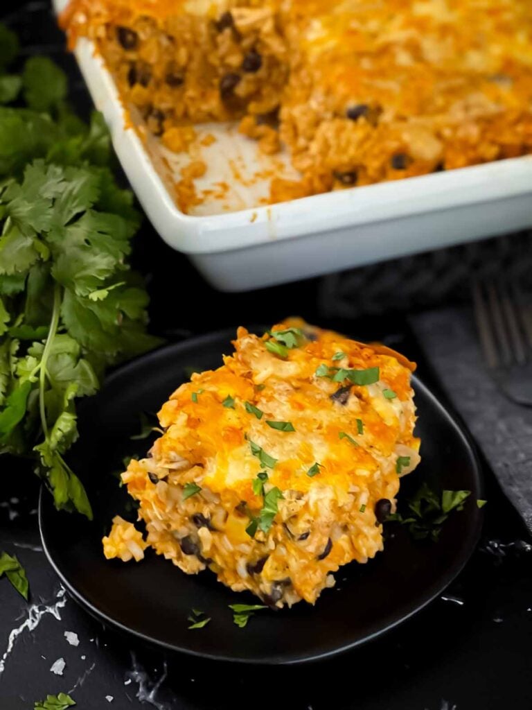 Chicken enchilada rice casserole on a black plate.