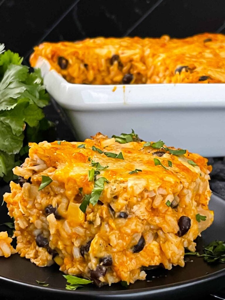 Chicken enchilada rice casserole on a black plate.