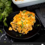 Chicken enchilada rice casserole on a black plate.