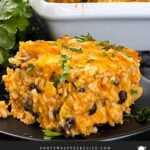 Chicken enchilada rice casserole on a black plate.