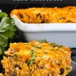 Chicken enchilada rice casserole on a black plate.