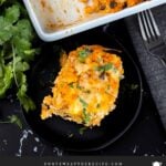 Chicken enchilada rice casserole on a black plate.